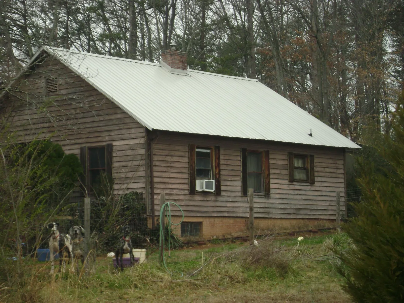 White metal roof on an old wood sided farmhouse, from a Metal Roof Installation job in Detroit